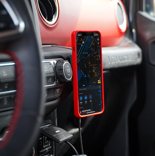 iPone with MagBak case mounted on a wireless charger on car dashboard