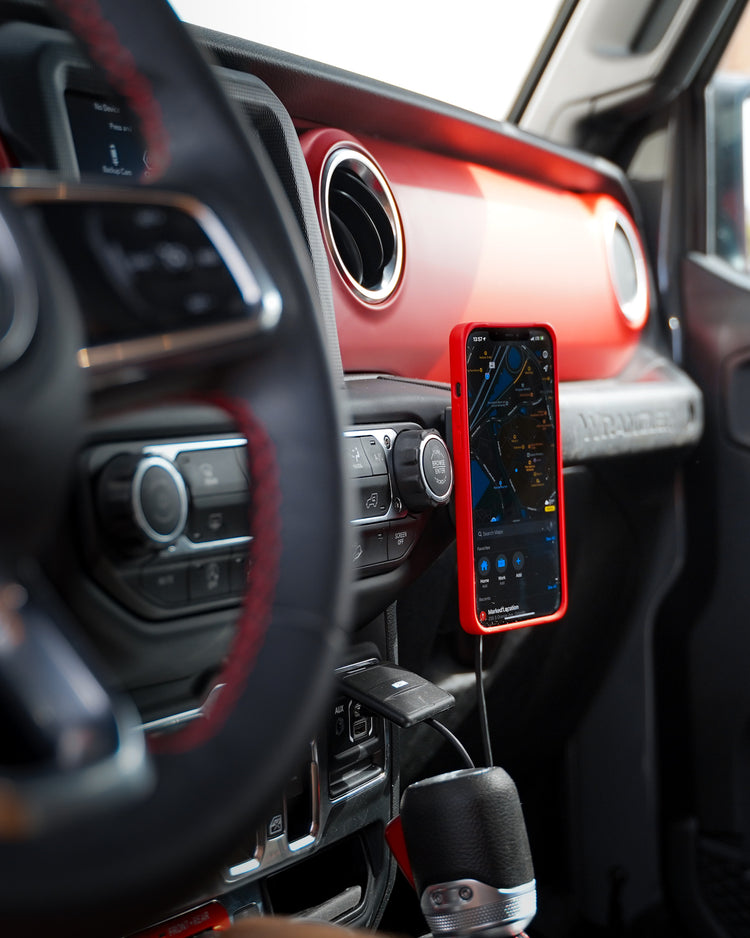 iPhone with MagBak case mounted on wireless charger on a car dashboard