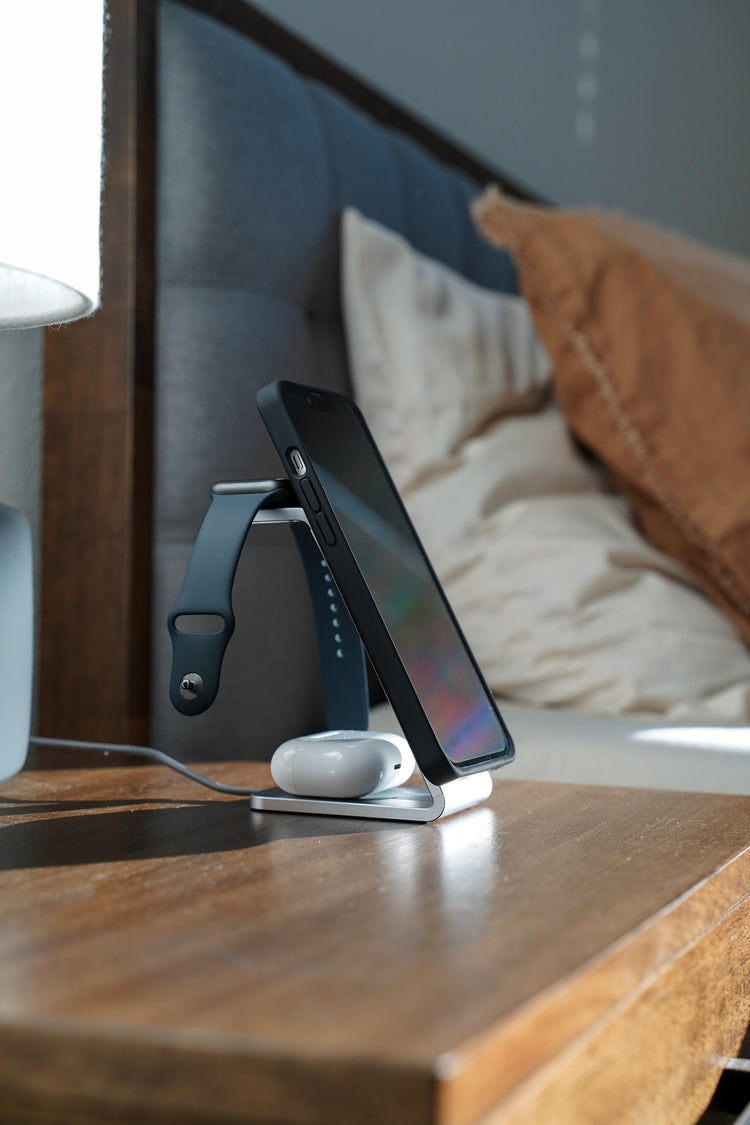 MultiCharger on nightstand next to bed charging iPhone, Apple watch, and AirPods