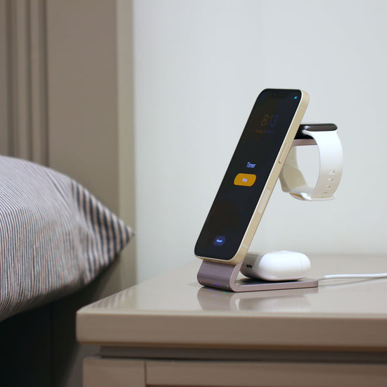 MultiCharger charging 3 devices sitting on night stand. 